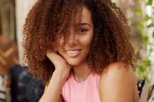 Femme afro qui pose avec ses cheveux ondulés