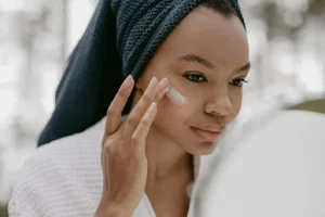 Femme noire qui applique un soin du visage